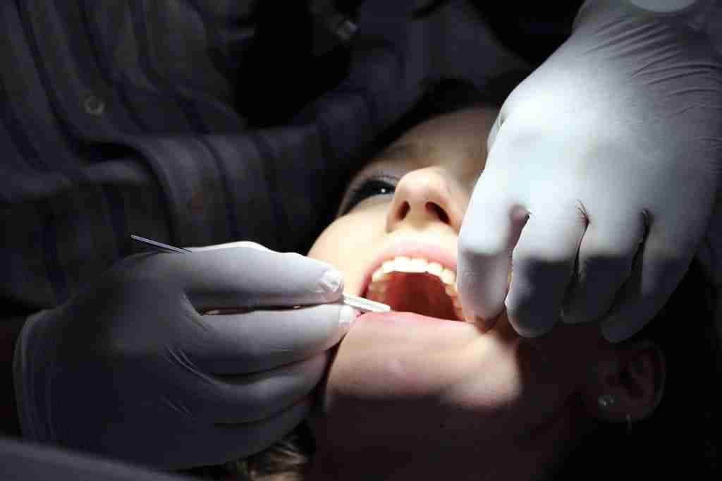 Patient in dentists chair with mouth open been examined following lost teeth accident. Woman with mouth open on dentist chair having her teeth treated after tooth damage