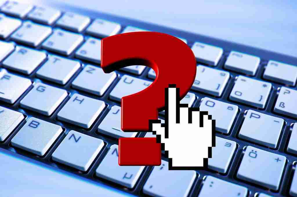 Computer keyboard with a hand ready to type a questions indicated by a large question mark. vaccine payment scheme frequently asked questions