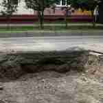 Deep unprotected road defect hole causing trip hazard