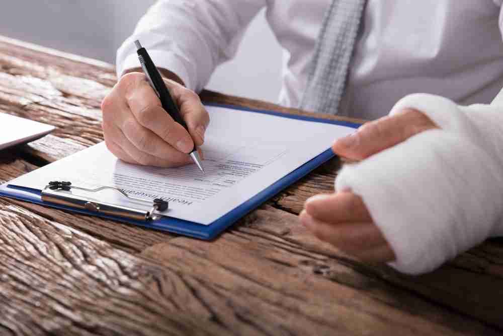 Injured man filling in documents to instruct solicitor. personal injury lawyer documents