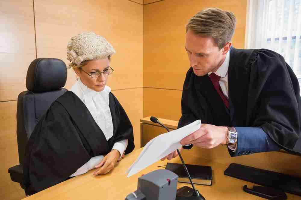 Litigation solicitor presenting evidence to judge in court Personal injury compensation litigation lawyer arguing case to judge in court