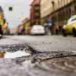 Pothole Trip Fall Accident Claim Pothole in a road near a manhole cover creating a trip hazard that could cause a fall accident
