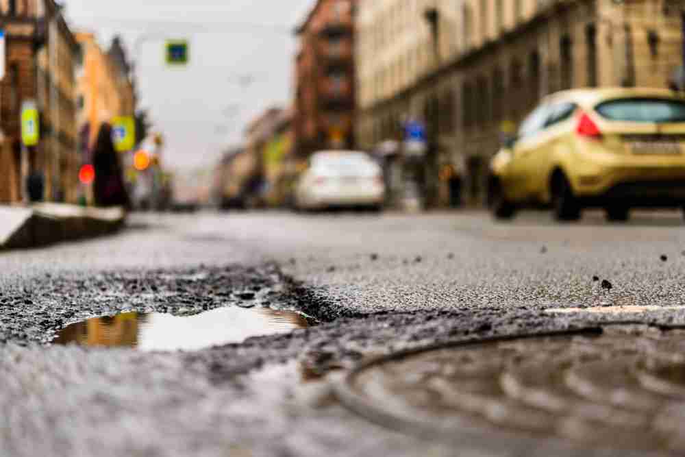 Pothole in a road creating a trip hazard that can cause a fall accident Pothole in a road creating a trip hazard that can cause a fall accident