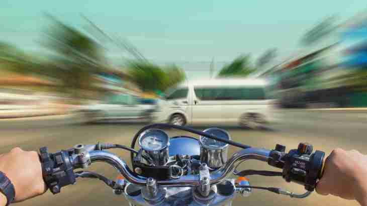 View from a motorcycle travelling towards a car and van crossing the rider's path