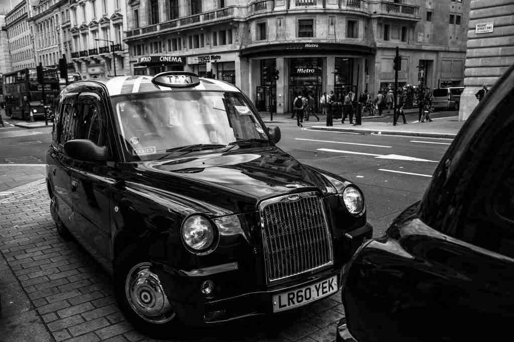 Black cabs waiting at a taxi rank on a city street for passengers