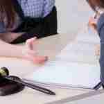 Person meeting with a solicitor whilst discussing an injury claim, with an injured arm supported by a sling